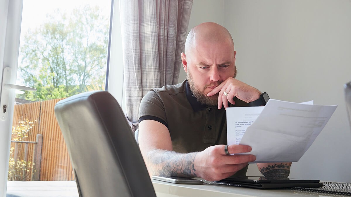 Man contemplating debt paperwork.